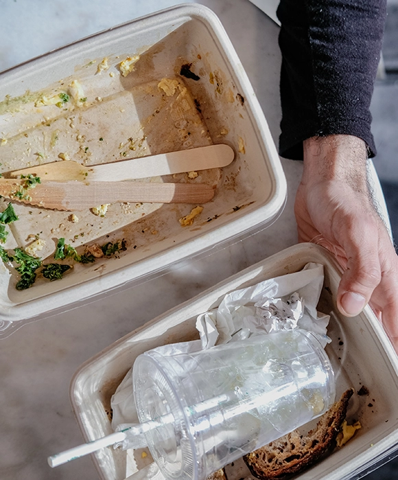Delta Container - Arten von Abfällen: Eine umfassende Übersicht Mann hält Lebensmittelbehälter aus Papier, Plastikbecher, Papierstrohhalm und Holzutensilien in den Händen